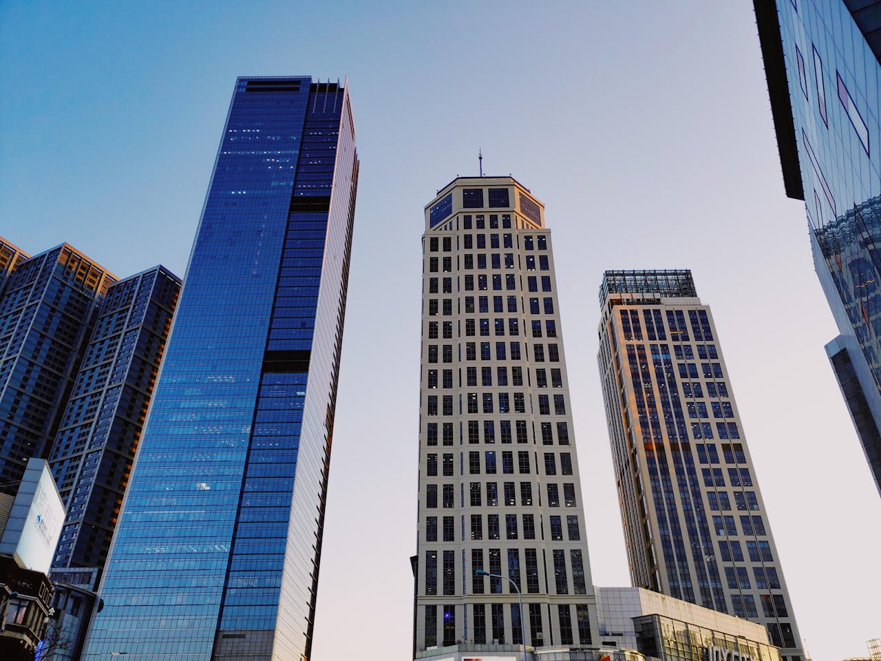 Perspective view of high rise skyscrapers under a clear sky, showcasing modern urban architecture.